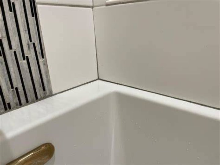 Should you caulk between tub and tile?